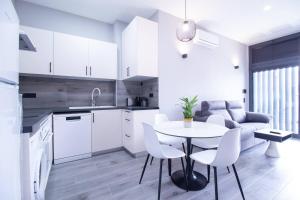 cocina y sala de estar con mesa y sillas en Patacona by Concept Flats, en Valencia