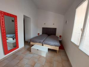 - une chambre avec un lit et un miroir dans l'établissement Gite Europa, à Le Mas