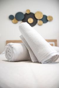 a stack of towels and buttons on a bed at Nautical Flats by Concept in Valencia