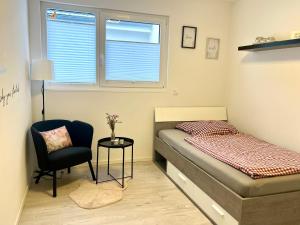 - une chambre avec un lit, une chaise et une fenêtre dans l'établissement Apartment Brochenzell - nahe Ravensburger Spieleland, à Meckenbeuren