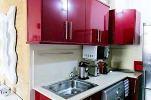 a kitchen with red cabinets and a sink at Serranos Flat by Concept Flats in Valencia