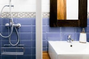a blue tiled bathroom with a shower and a sink at Serranos Flat by Concept Flats in Valencia