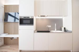 cocina con armarios blancos y fogones en MARITIM 1 by Concept, en Valencia