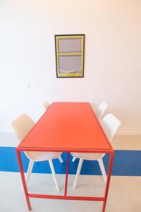 una mesa roja y 2 sillas blancas en una habitación en Marino by Concept, en Valencia