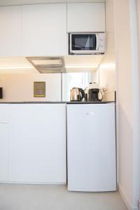 una pequeña cocina con armarios blancos y microondas en Marino by Concept, en Valencia