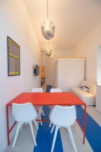 Habitación con mesa roja y sillas blancas. en Marino by Concept, en Valencia