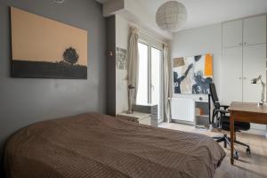 een slaapkamer met een bed, een bureau en een computer bij Atypical Luxury House near Paris in Boulogne-Billancourt