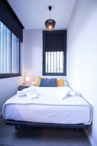 1 dormitorio con 1 cama blanca grande y ventana en Patacona by Concept Flats en Valencia