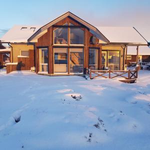 a log cabin in the snow with snow at Austefjorden Fjordsuite med Panoramautsikt in Forland