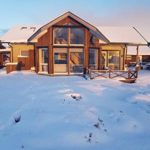 una cabaña de madera en la nieve con nieve en Austefjorden Fjordsuite med Panoramautsikt, en Forland