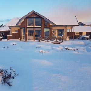 a house in the snow with animals in the yard at Austefjorden Fjordsuite med Panoramautsikt in Forland +16 photos