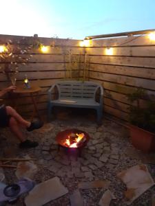 a fire pit on a patio with a bench and lights at Little Pedn in Penzance
