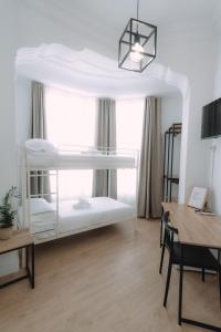 バレンシアにあるClink Rooms & Flatsの二段ベッド2台、デスクが備わる客室です。