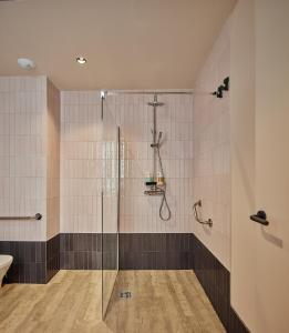 a bathroom with a shower with a glass door at VG - Villa de Andas suites in Cádiz