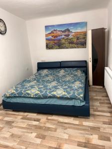 a bedroom with a bed and a painting on the wall at Apartament Diaconu Coresi (Piata Sfatului) in Braşov