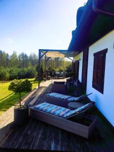 eine Terrasse mit einem Sofa und einem Tisch auf einer Terrasse in der Unterkunft Siedlisko pod Aniołem in Grabówko