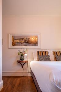 a bedroom with a bed and a vase of flowers on a table at Hotel Restaurant Café Parkzicht in Roermond