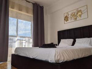 a bedroom with a large bed and a window at Rooms 10 mins walk from train station! in Agualva