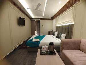a hotel room with a bed and a couch at Hotel Gagan Plaza in Kānpur