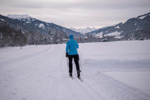 a person is standing on skis in the snow at Alte Bildhauerei in Aurach bei Kitzbuhel