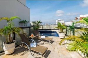 a balcony with chairs and a swimming pool on a building at Executive Flat Bela Cintra 704 in Sao Paulo