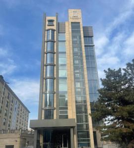 un edificio alto con un reloj encima en City Stay Bishkek en Bishkek