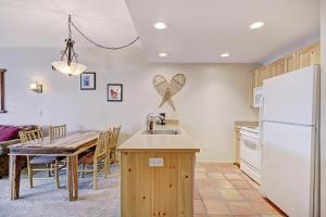 una cucina e una sala da pranzo con tavolo e frigorifero di TX202 Taylors Crossing condo a Copper Mountain