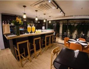 un bar dans un restaurant avec une table et des chaises dans l'établissement Executive Flat Bela Cintra 704, à São Paulo