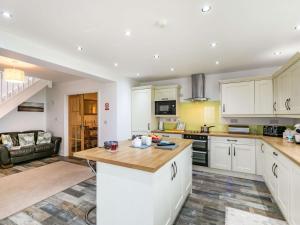 une cuisine avec des placards blancs et un salon dans l'établissement 3 Bed in Bridlington 56248, à Weaverthorpe