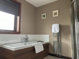 a bathroom with a bath tub and a shower at Dog friendly 6- Bedroom House in Isle of Lewis - great for families and large groups in Garrabost