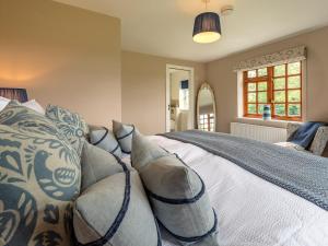 ein Schlafzimmer mit einem Bett mit Kissen in der Unterkunft 3 Bed in Ross-on-Wye 75491 in Llangarren