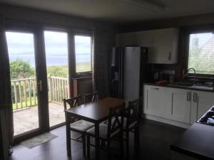 a kitchen with a table and chairs and a kitchen with a balcony at Dog friendly 6- Bedroom House in Isle of Lewis - great for families and large groups in Garrabost