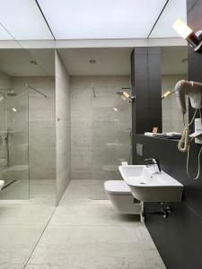 a bathroom with a toilet and a sink and a shower at Black Gold Center in Chorzów