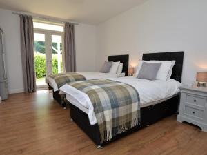 1 Schlafzimmer mit 2 Betten und einem Fenster in der Unterkunft 3 Bed in Lulworth 49005 in Owermoigne
