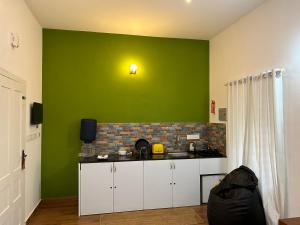ワイナードにあるSilver Oak By Exuberance Stays (Independent Holiday Home)の緑の壁のキッチン(カウンタートップ付)