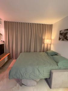 a bedroom with a green bed and a window at Studio climatisé 600m de la plage in Cagnes-sur-Mer