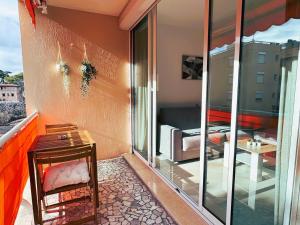 uma varanda com uma mesa e uma porta de vidro em Studio climatisé 600m de la plage em Cagnes-sur-Mer