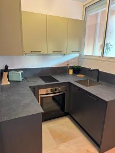 a kitchen with a sink and a stove at Studio climatisé 600m de la plage in Cagnes-sur-Mer