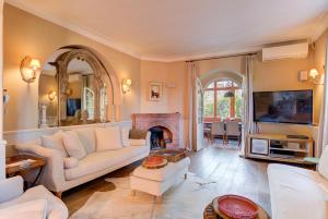 a living room with white furniture and a fireplace at Bastide Les Cigales in Antibes