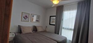 Schlafzimmer mit einem Bett und einem Fenster in der Unterkunft Modern house with 2 bedrooms near the beach in Castillo del Romeral