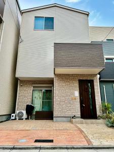 ein weißes Haus mit einer schwarzen Tür in der Unterkunft Free Parking Namba south Villa 4 rooms 120m2 in Osaka