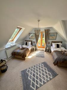 a attic room with two beds and a window at Awakening Alchemy Retreat Centre in Inverurie