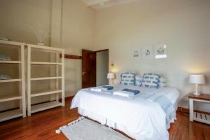 a bedroom with a bed with blue and white pillows at Mar Azul 1B in Ponta Malongane