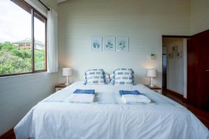 a bedroom with a large bed with blue and white pillows at Mar Azul 1B in Ponta Malongane
