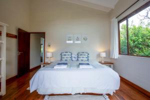 a bedroom with a large white bed with blue pillows at Mar Azul 1B in Ponta Malongane