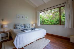1 dormitorio con cama grande y ventana grande en Mar Azul 1B, en Ponta Malangane
