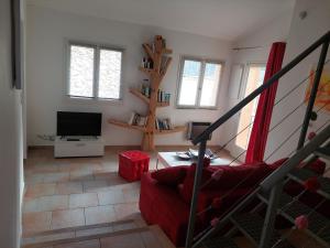 Gite Europa في Le Mas: غرفة معيشة بها أريكة حمراء وتلفزيون