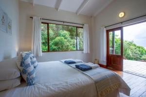 a bedroom with a bed and a large window at Mar Azul 1B in Ponta Malongane