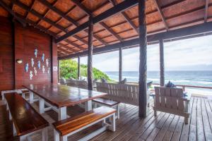 a dining room with a table and chairs and the ocean at Mar Azul 1B in Ponta Malongane