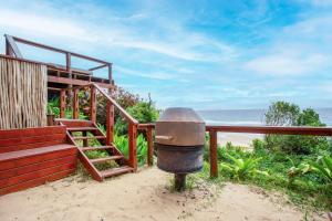 a building with stairs and a trash can next to the beach at Mar Azul 1B in Ponta Malongane